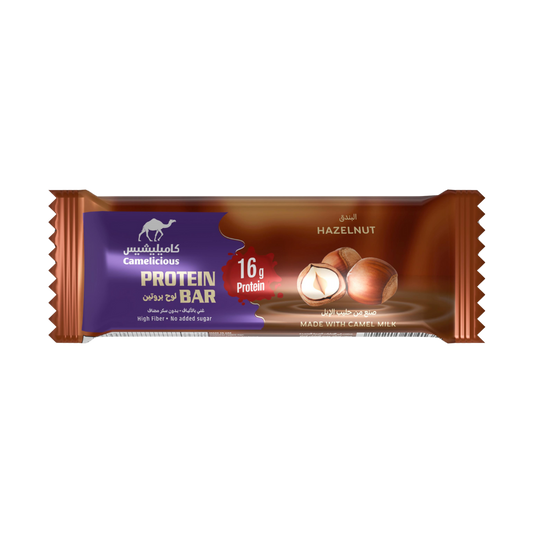 Camelicious Hazelnut Protein Bar 60g made with camel milk, featuring 16g of protein, high fiber, and no added sugar, in brown and purple packaging with hazelnut imagery.